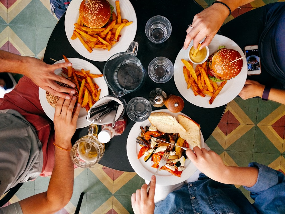 Friends sharing burgers and fries around a table