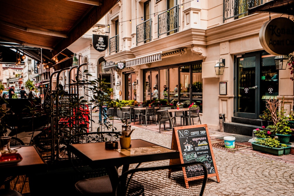 A cafe storefront with sidewalk tables and a chalkboard menu